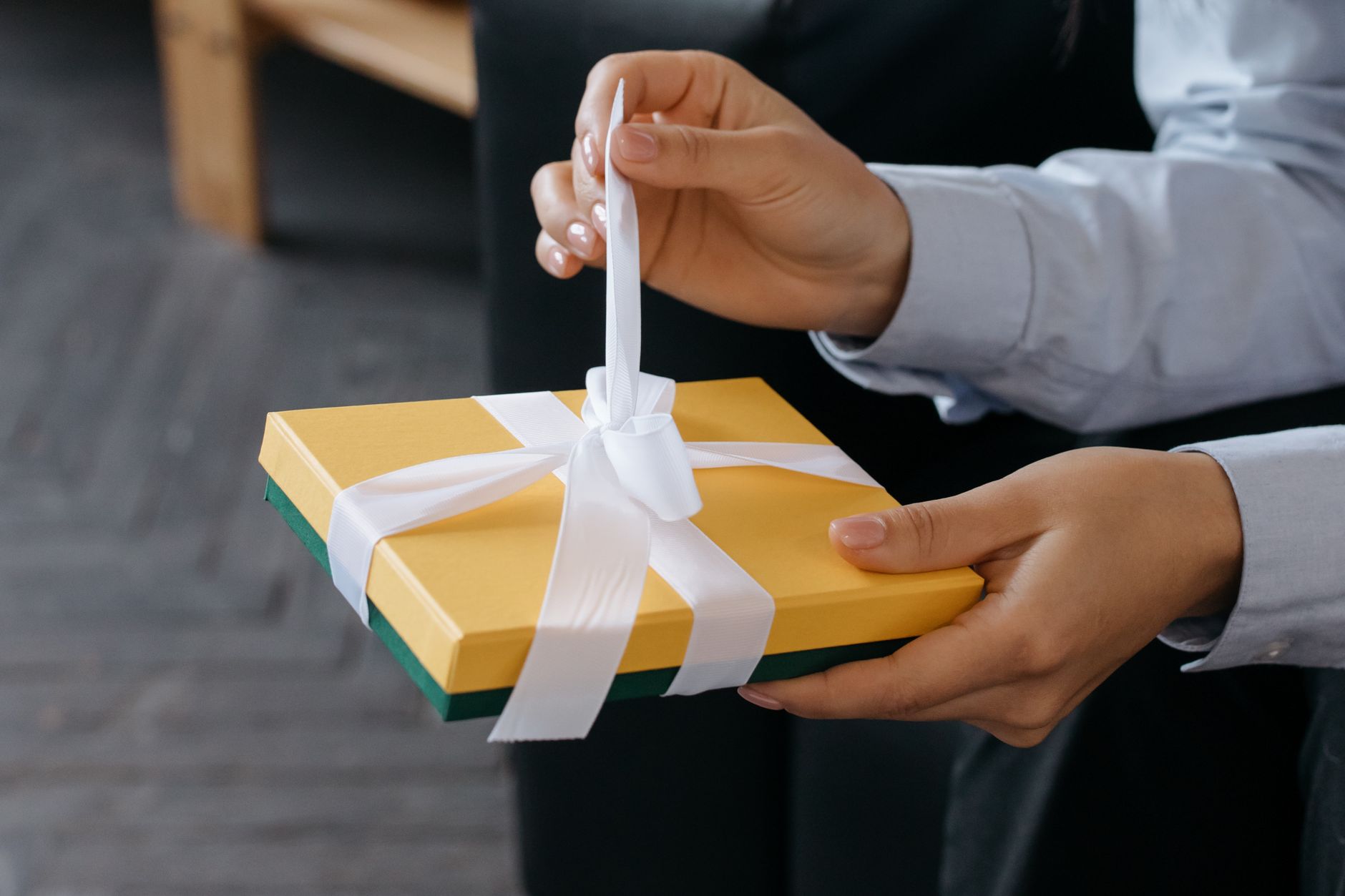 a person untying the ribbon on a gift box